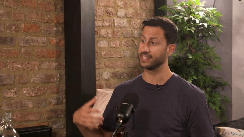 Mike Bandar speaking into a podcast microphone during an interview